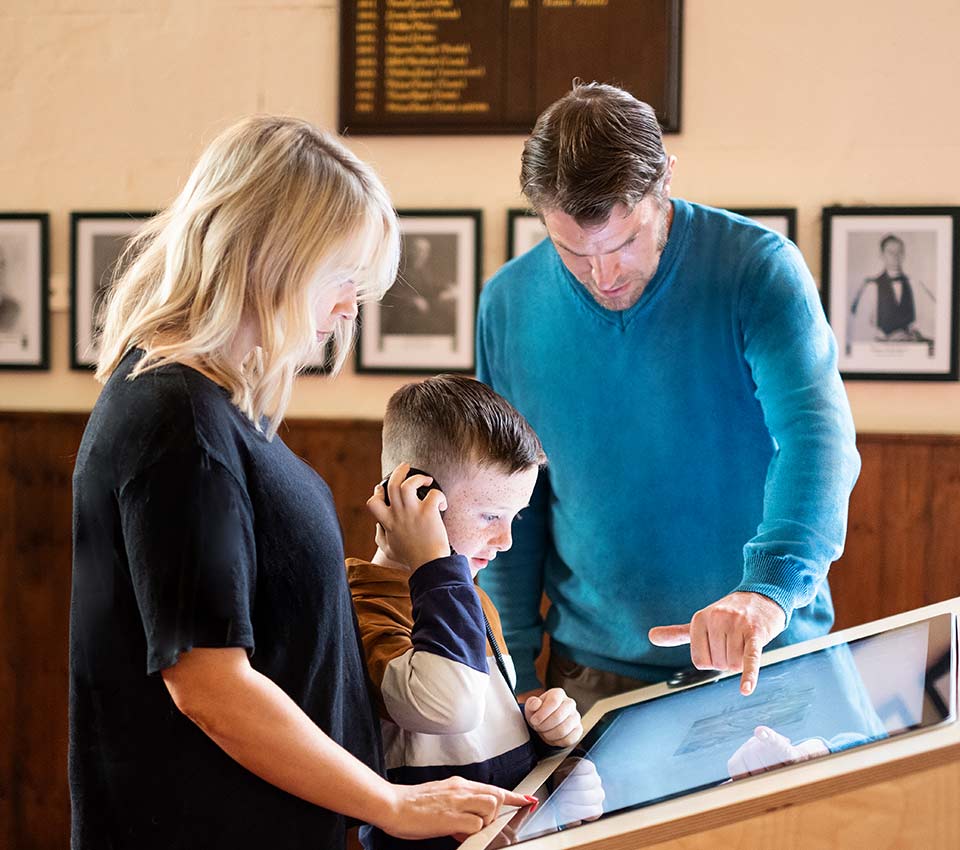 A family looking closely at a display in St Mary's Collegiate Church.